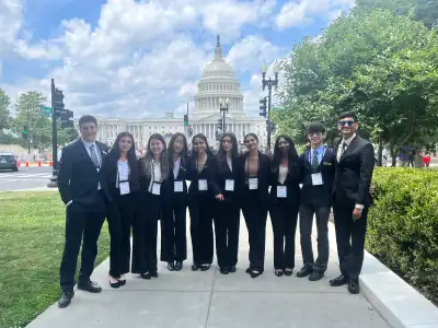 Students huddled together for a group photo in front of the Capitol